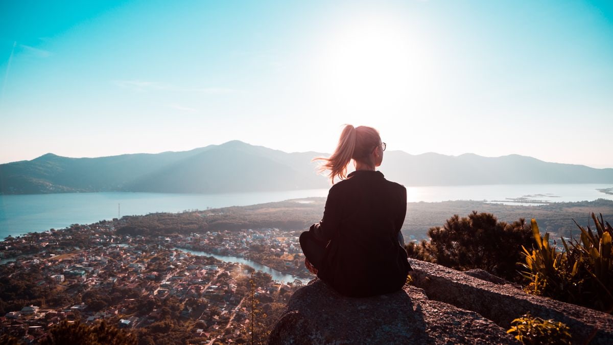 A person enjoying a tranquil mountain view at sunset, reflecting solitude.